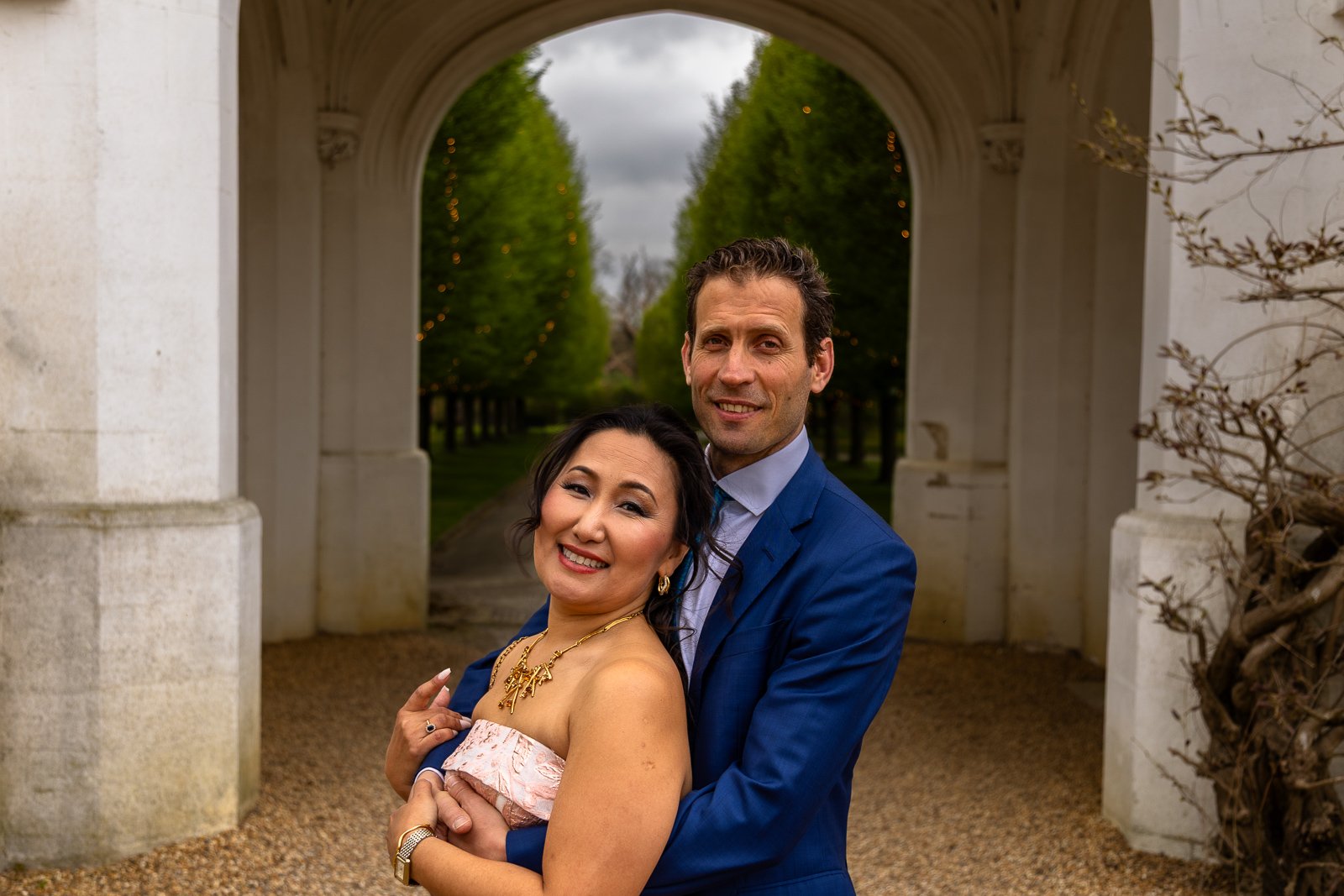 Couple hug each other while posing.