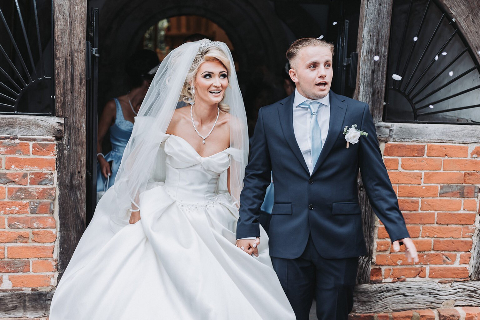 Bride and groom are exiting the St Peter's church in Ash Green during wedding photography.