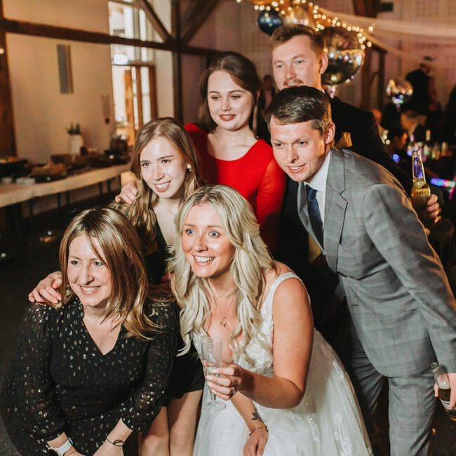 Bride is posing with her guests at the wedding party during wedding photography.