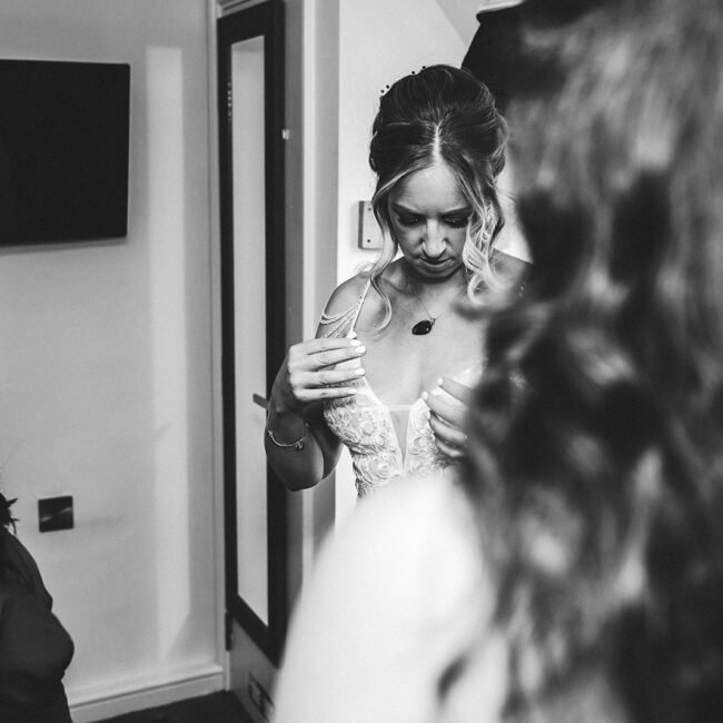 Bride is checking her wedding dress during wedding photography.