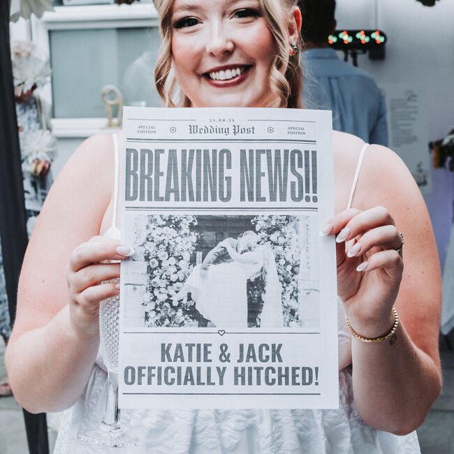 Bride is holding a leaflet that looks like a newspaper about her wedding during wedding photography.